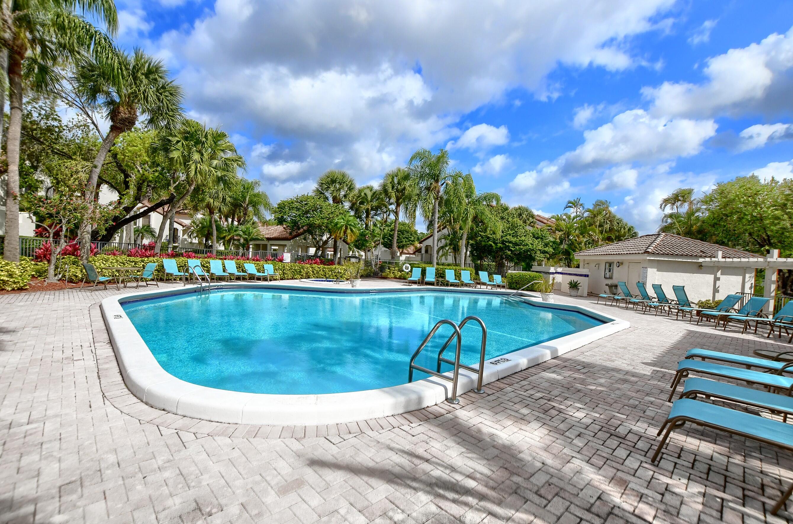 7896 Seville Place, Unit 1501 Boca Raton, FL 33433 - Photo 30 of 32 a view of a swimming pool with a lounge chairs