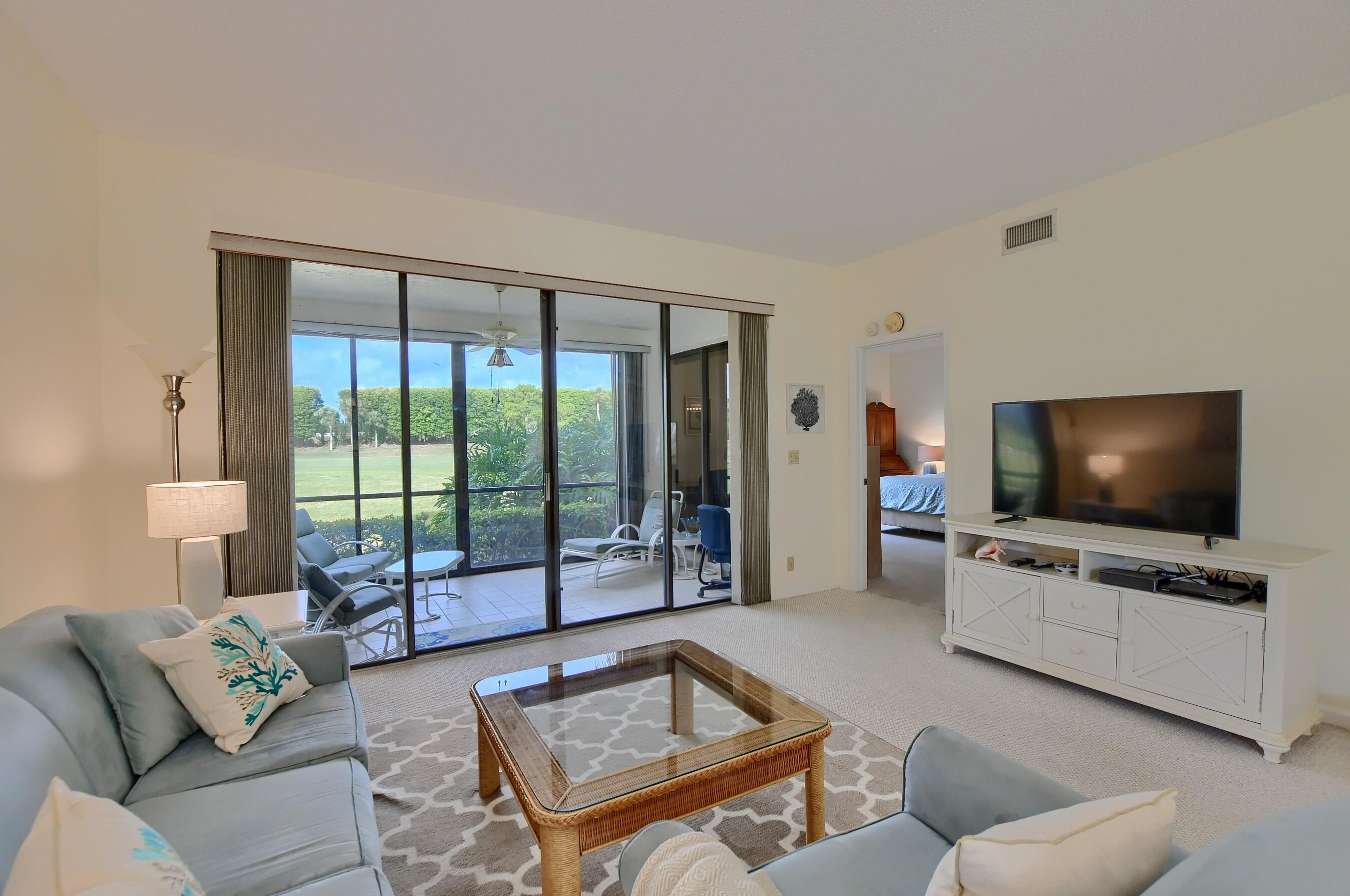 7896 Seville Place, Unit 1501 Boca Raton, FL 33433 - Photo 5 of 32 a living room with furniture and a flat screen tv