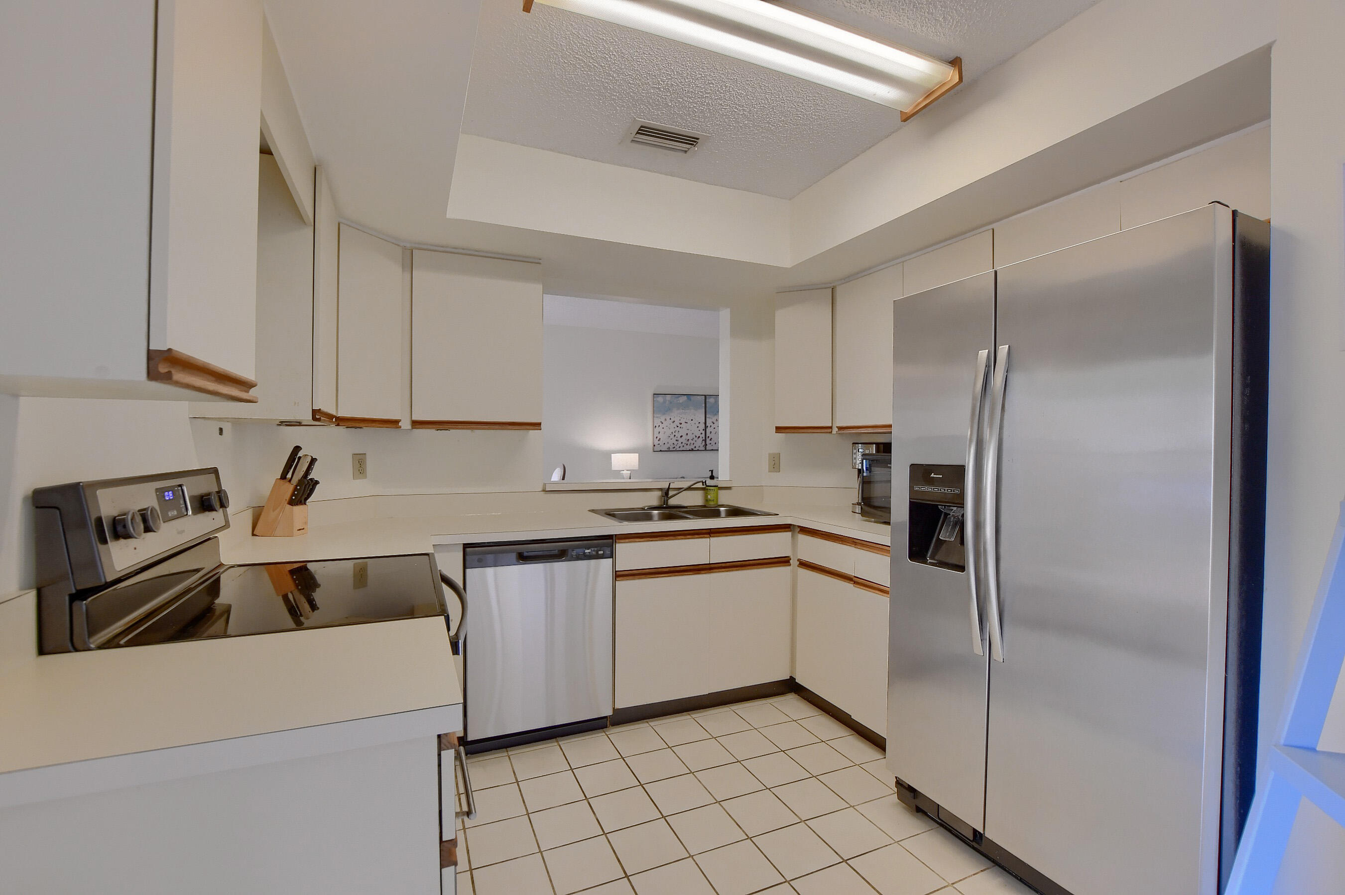 7896 Seville Place, Unit 1501 Boca Raton, FL 33433 - Photo 10 of 32 a kitchen with a sink a refrigerator and cabinets