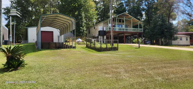 a front view of house with yard and trees in the background