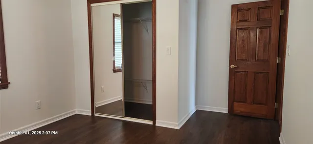 an empty room with wooden floor and closet