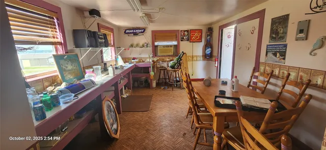 a dining room with furniture window and wooden floor