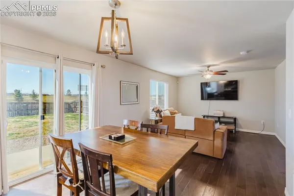 a kitchen with stainless steel appliances granite countertop a sink dishwasher cabinets a dining table and chairs with wooden floor