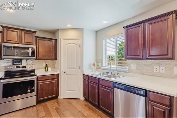 a kitchen with stainless steel appliances granite countertop a refrigerator stove and sink