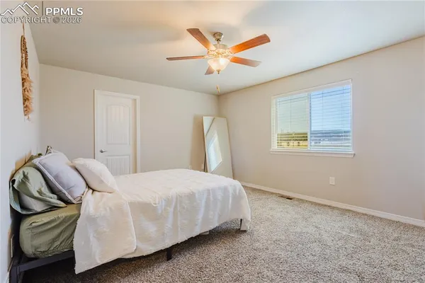 a bedroom with a bed and a ceiling fan