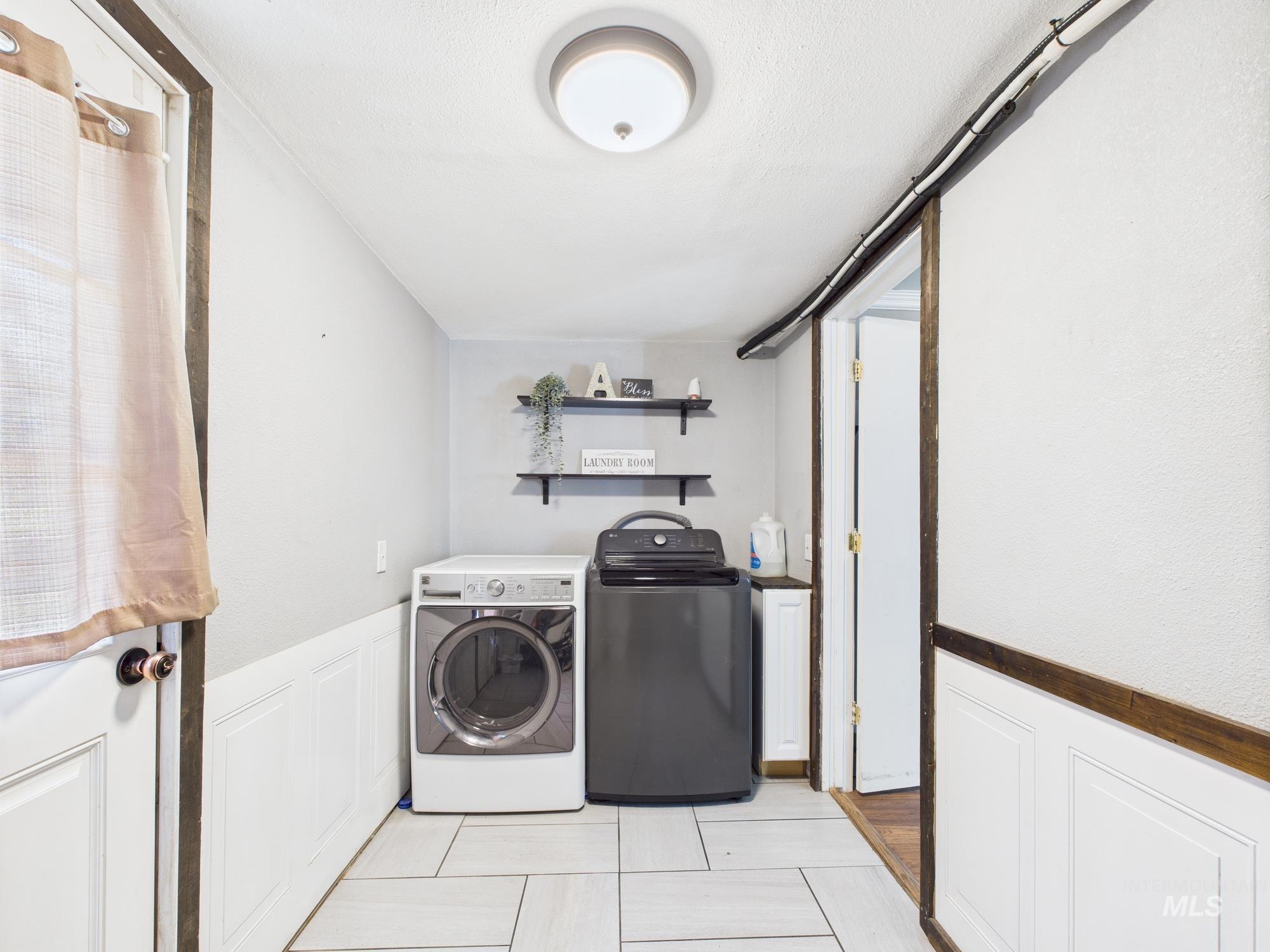 1428 Bryden Avenue Lewiston, ID 83501 - Photo 15 of 32 Laundry area featuring separate washer and dryer, wainscoting, and light tile patterned flooring