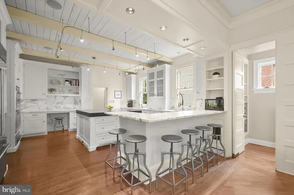 a large white kitchen with kitchen island a table and chairs in it