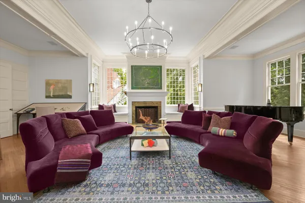 a living room with furniture a fireplace and a chandelier