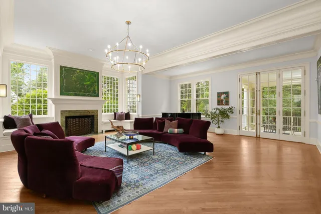 a living room with furniture a fireplace and a chandelier