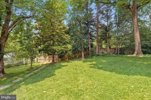 a view of a house with a cars park side of a road