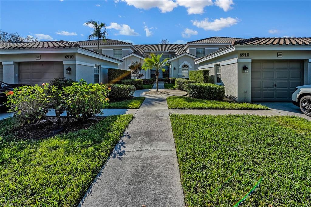 6910 Satinleaf Road North, Unit 101 Naples, FL 34109 - Photo 3 of 30 View of front of property with a garage and a front yard
