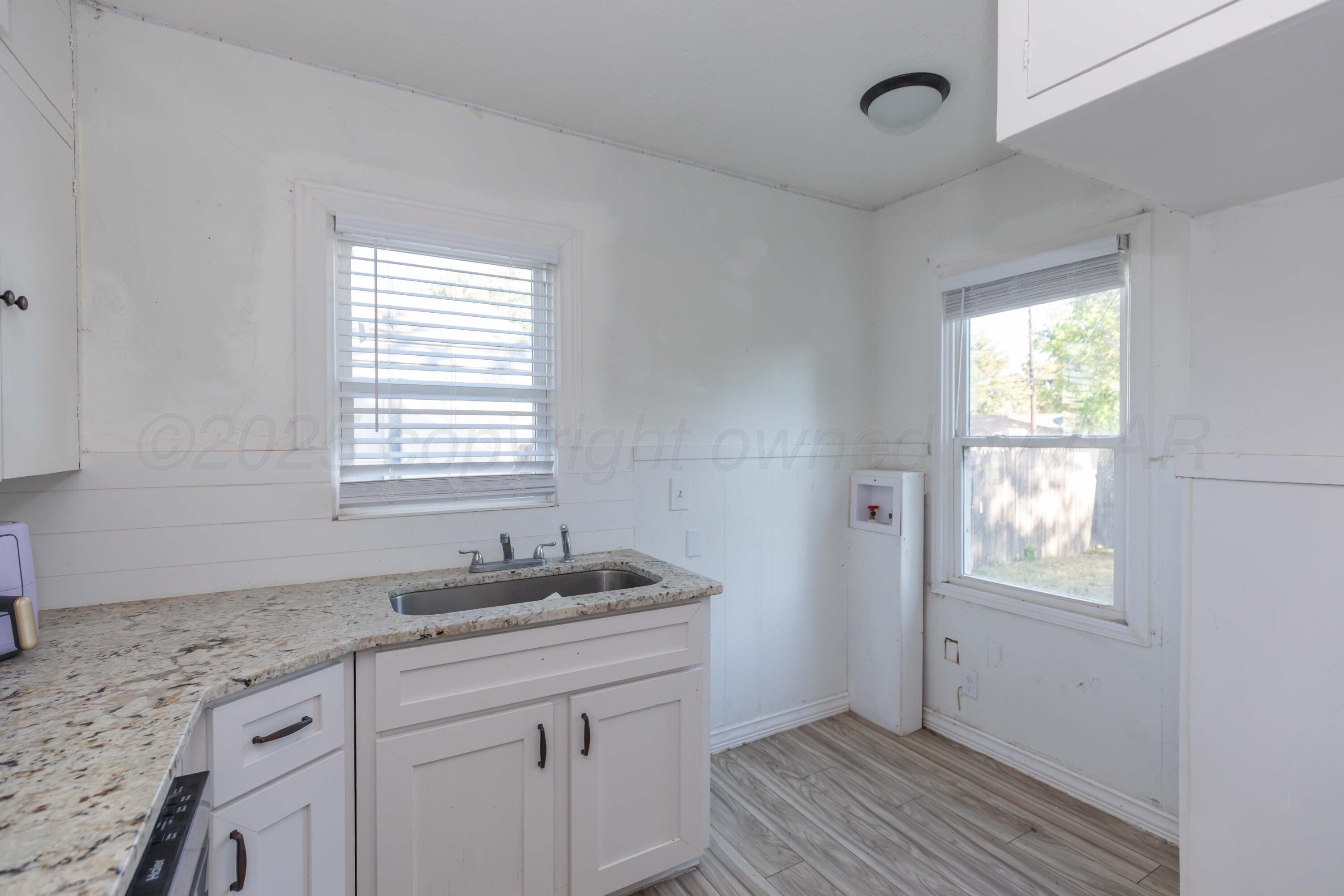 1214 Southwest 12th Avenue Amarillo, TX 79102 - Photo 11 of 25 a bathroom with a granite countertop sink a window and a mirror