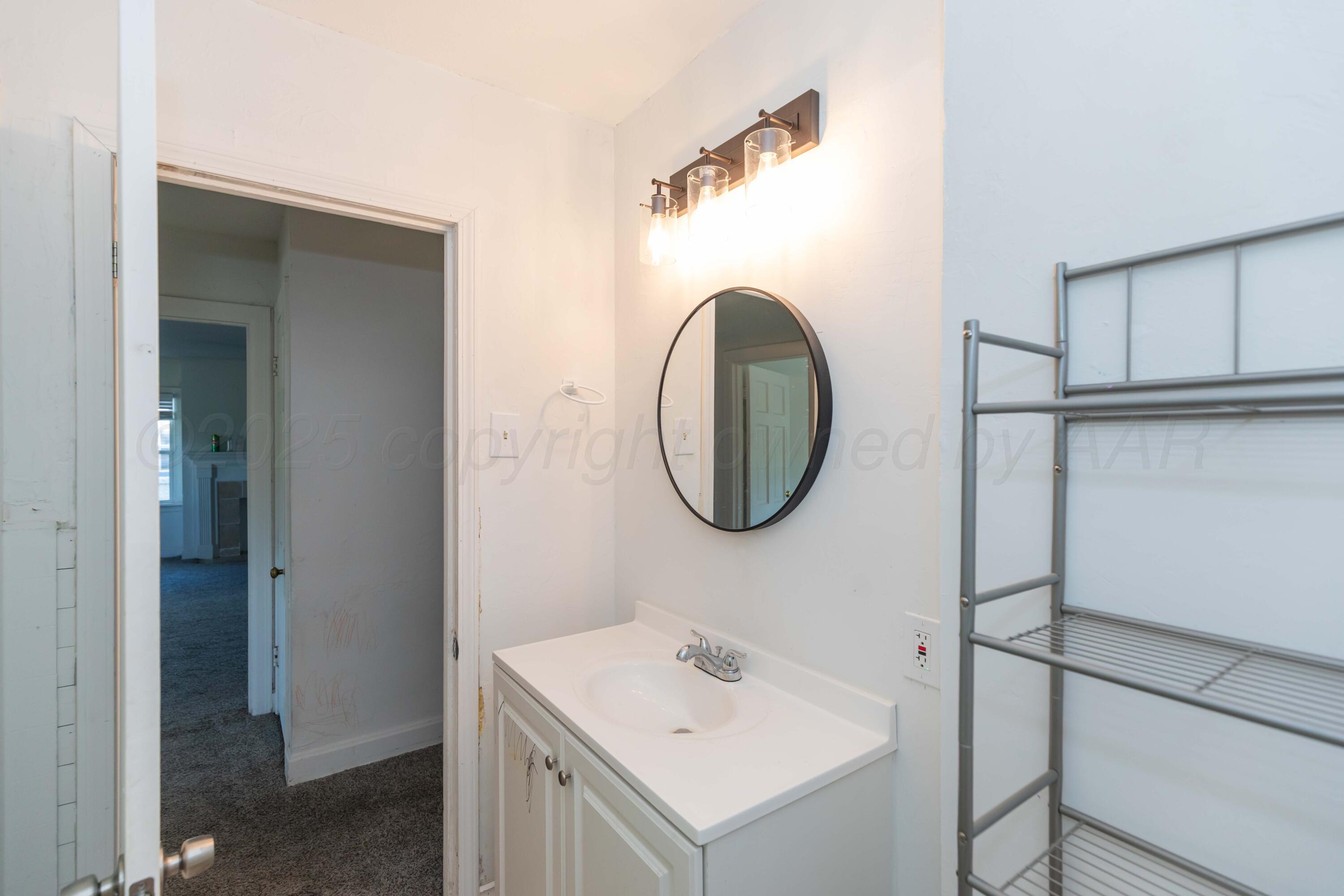 1214 Southwest 12th Avenue Amarillo, TX 79102 - Photo 13 of 25 a bathroom with a sink and a mirror