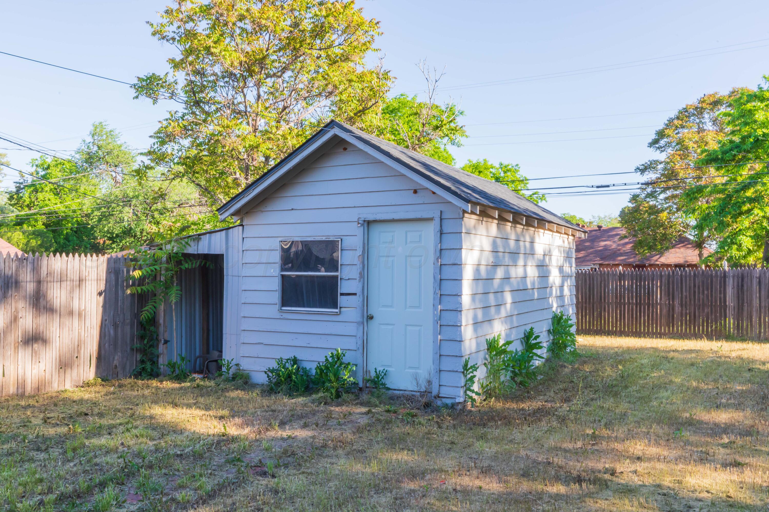 1214 Southwest 12th Avenue Amarillo, TX 79102 - Photo 25 of 25 a view of a brick house with a yard plants and large tree
