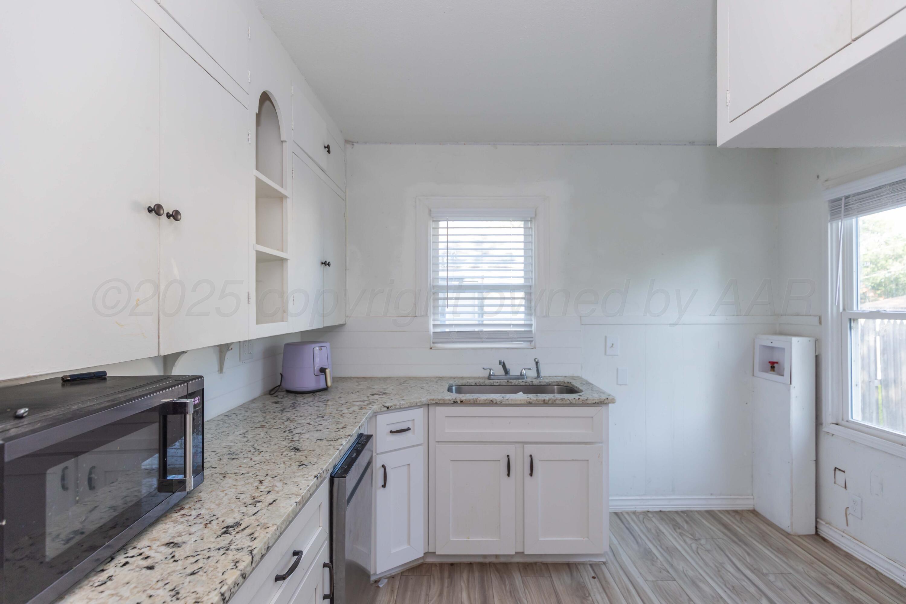 1214 Southwest 12th Avenue Amarillo, TX 79102 - Photo 9 of 25 a kitchen with granite countertop a sink stove and cabinets