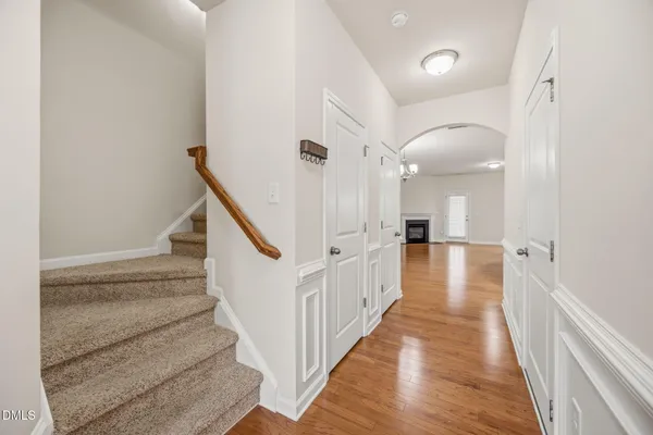 a view of a hallway with wooden floor and staircase