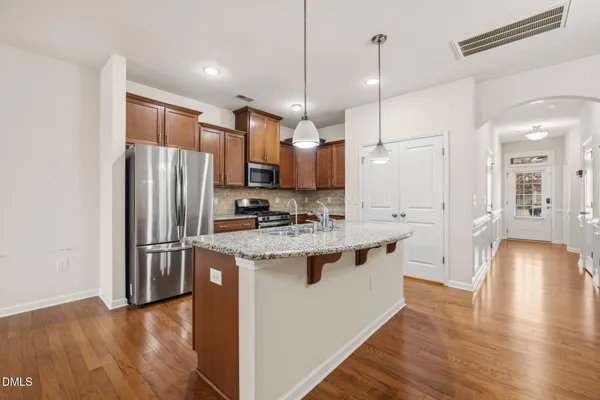 a kitchen with kitchen island a refrigerator stove and oven
