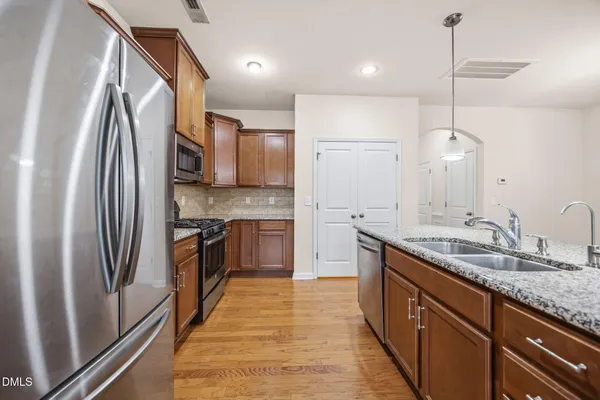 a kitchen with stainless steel appliances granite countertop a sink refrigerator and cabinets