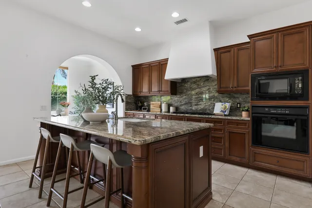 a kitchen with stainless steel appliances a sink table and chairs