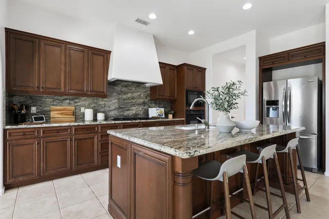 a kitchen with stainless steel appliances granite countertop a sink and a refrigerator