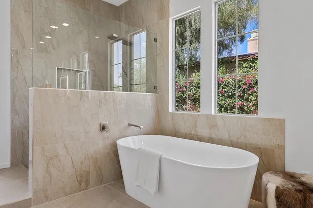 a white bath tub sitting in a bathroom next to a window