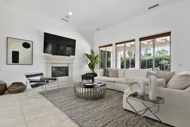 a living room with furniture a flat screen tv and a fireplace