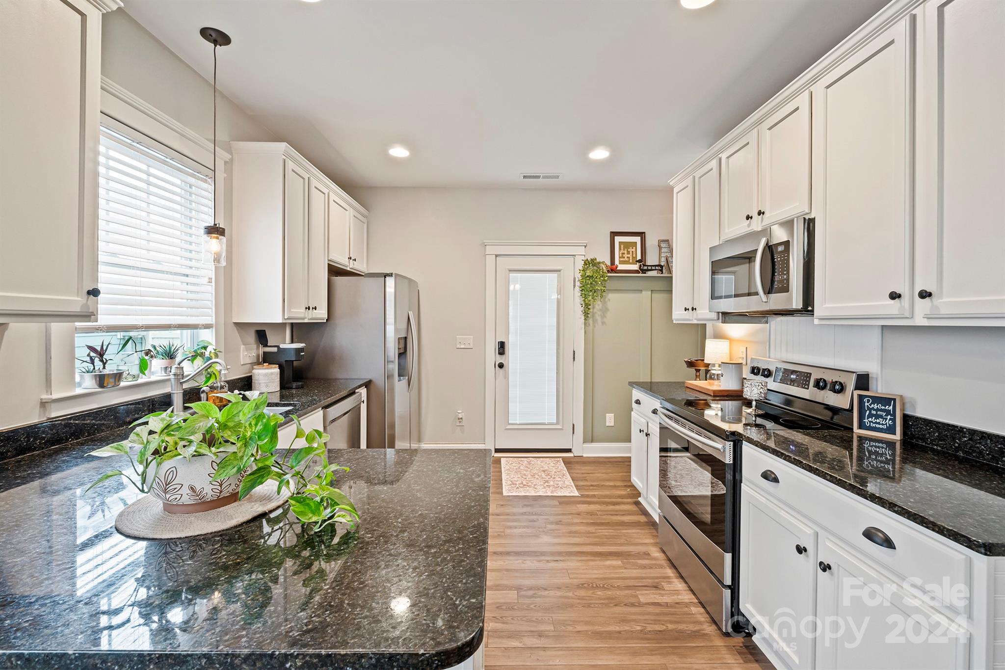 13516 Stumptown Road Huntersville, NC 28078 - Photo 15 of 37 a kitchen with stainless steel appliances a stove a sink cabinets and a wooden floor