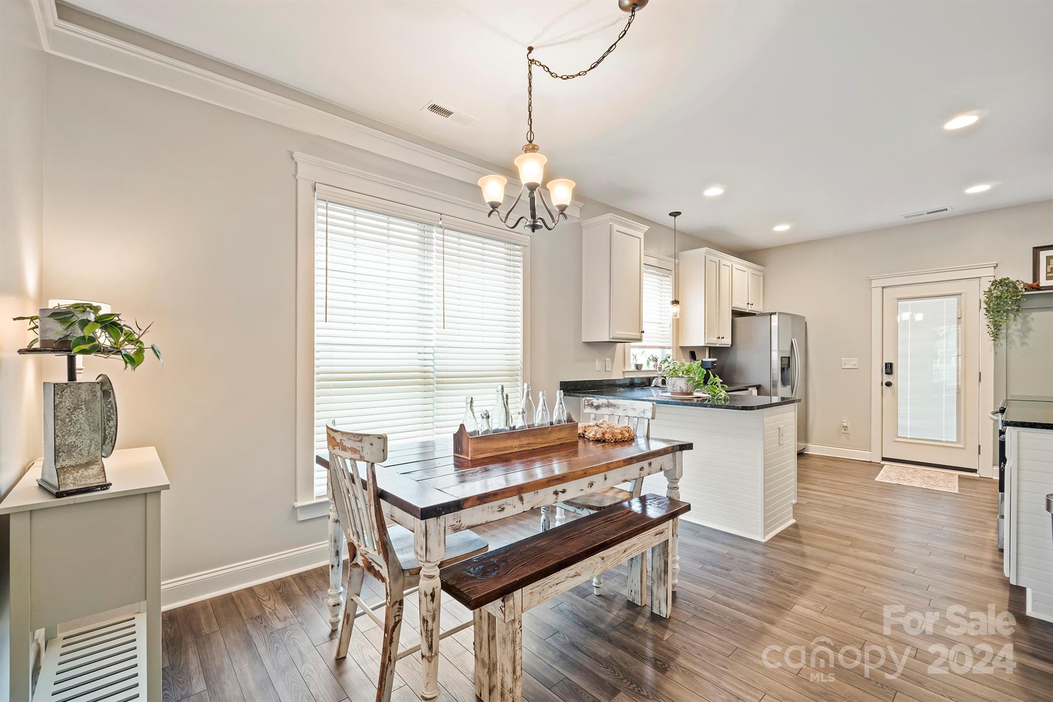 13516 Stumptown Road Huntersville, NC 28078 - Photo 8 of 37 a dining room with wooden floor and a chandelier