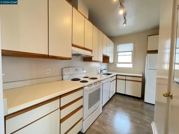 a kitchen with a white cabinets and wooden floor