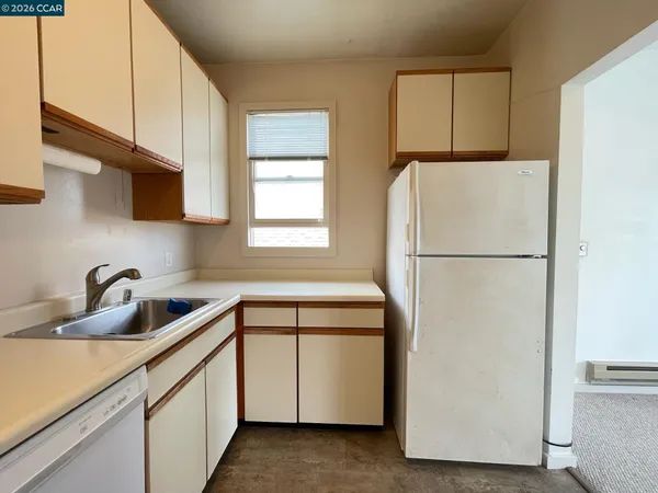 a kitchen with a refrigerator sink and cabinets