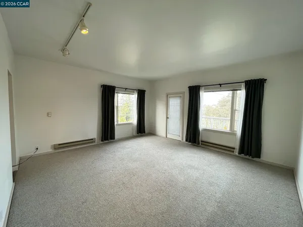 an empty room with windows and closet