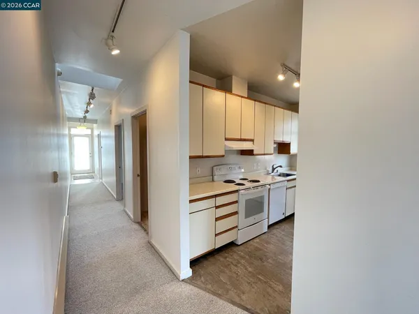 a kitchen with stainless steel appliances white cabinets and a refrigerator