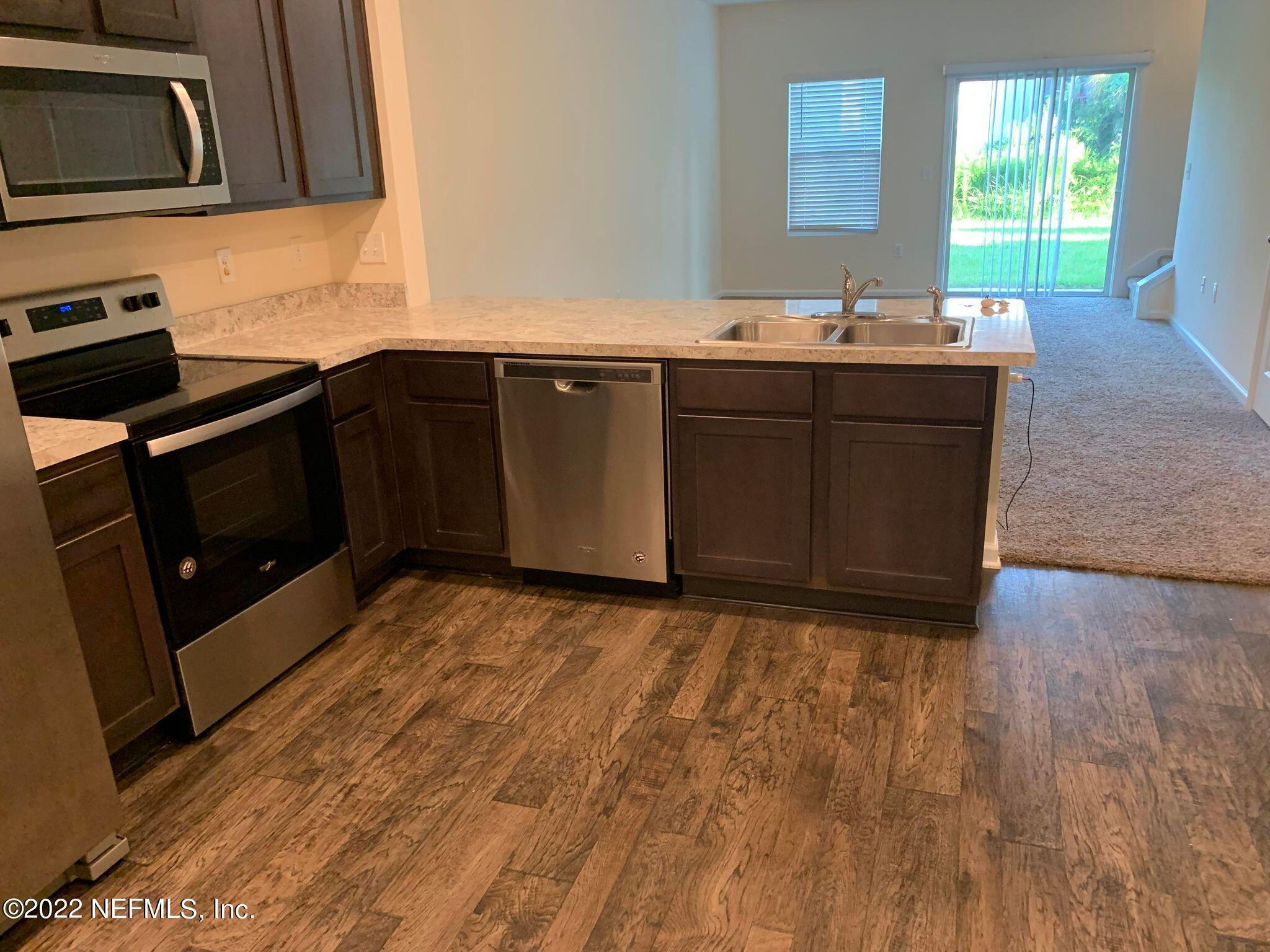 8023 Echo Springs Road Jacksonville, FL 32256 - Photo 2 of 9 a kitchen with stainless steel appliances granite countertop a stove a sink and a microwave