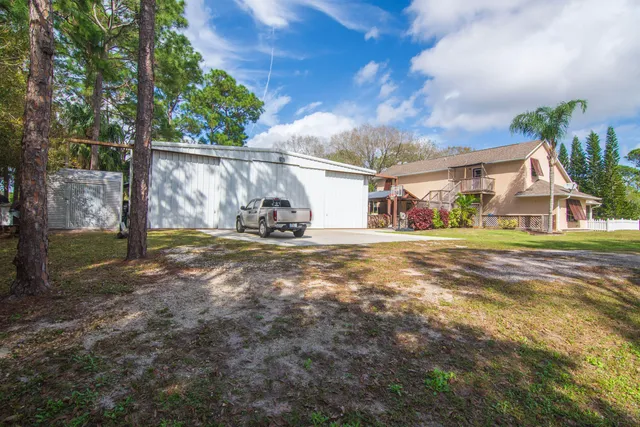 a view of a house with a yard and potted plants