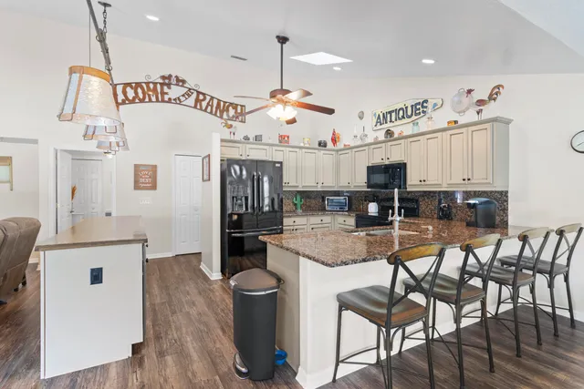 a kitchen with stainless steel appliances kitchen island granite countertop a stove a sink and a refrigerator