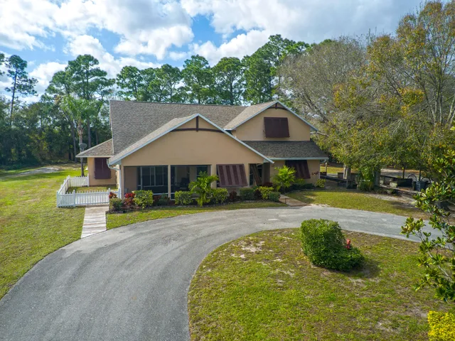 a front view of a house with swimming pool having outdoor seating