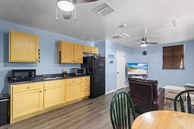 a kitchen with stainless steel appliances granite countertop white cabinets a dining table and chairs