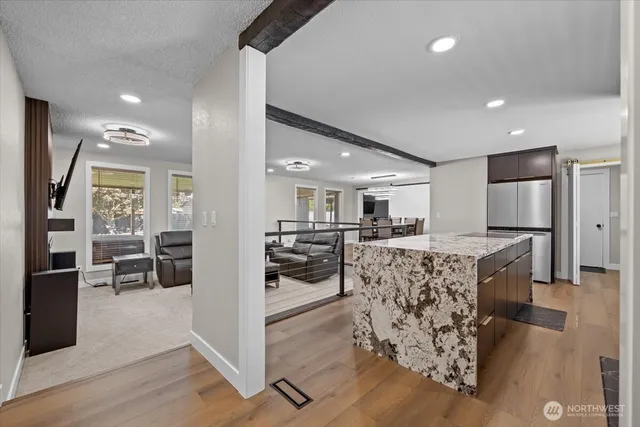 a kitchen with stainless steel appliances granite countertop a kitchen island a stove and a refrigerator