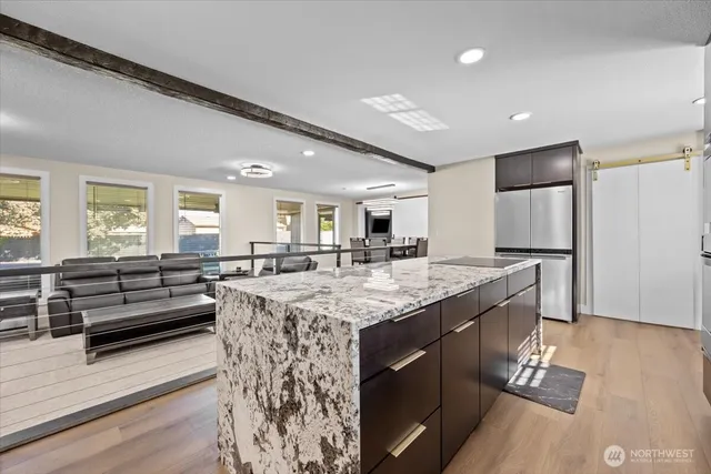 a kitchen with stainless steel appliances granite countertop a refrigerator a stove and a wooden floors