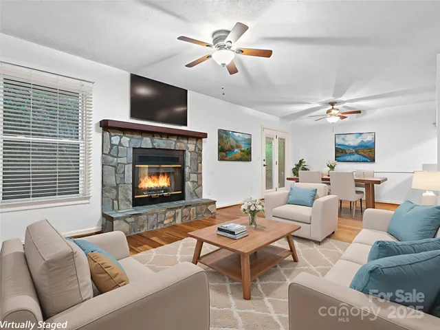 a living room with furniture a fireplace and a flat screen tv