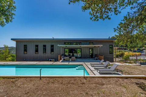 a kitchen with a table chairs and a potted plant