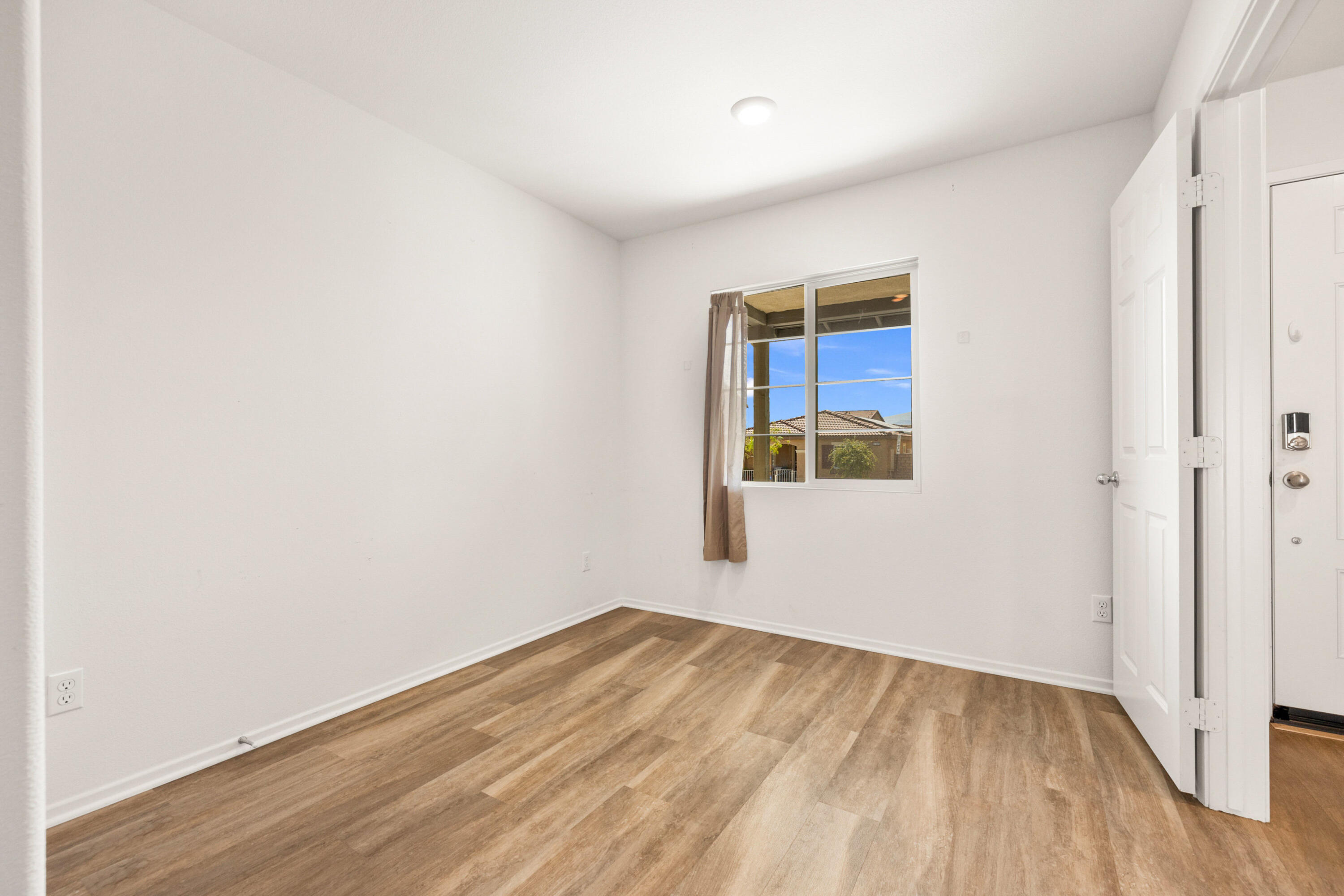 67364 Rio Plata Road Cathedral City, CA 92234 - Photo 13 of 49 a view of an empty room with wooden floor and a window