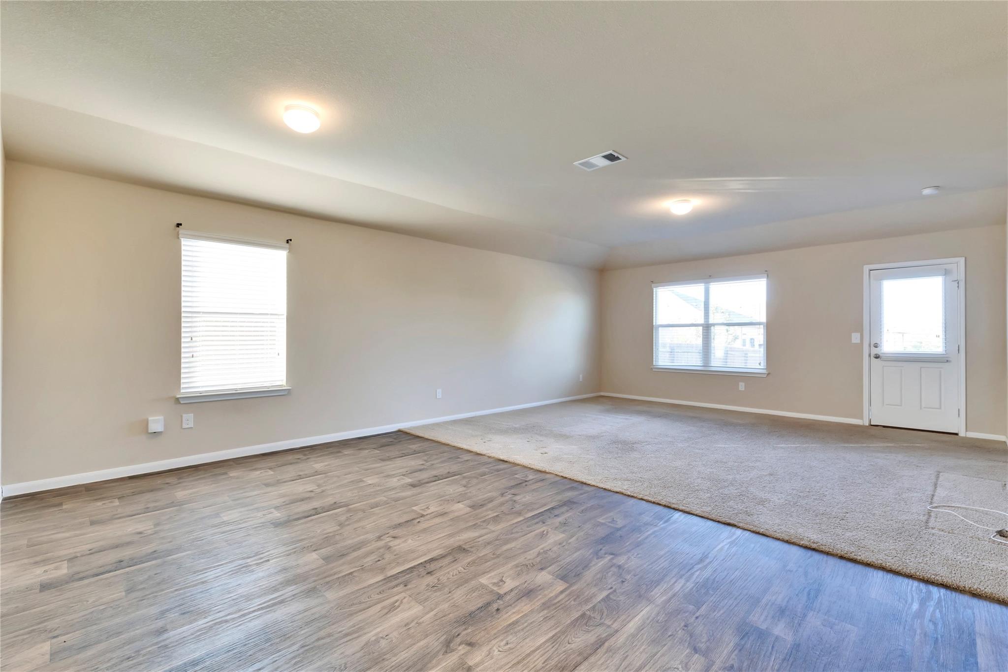5913 Diamondleaf Bend Austin, TX 78724 - Photo 11 of 20 Open-concept living space featuring wood-finish flooring and neutral carpeting