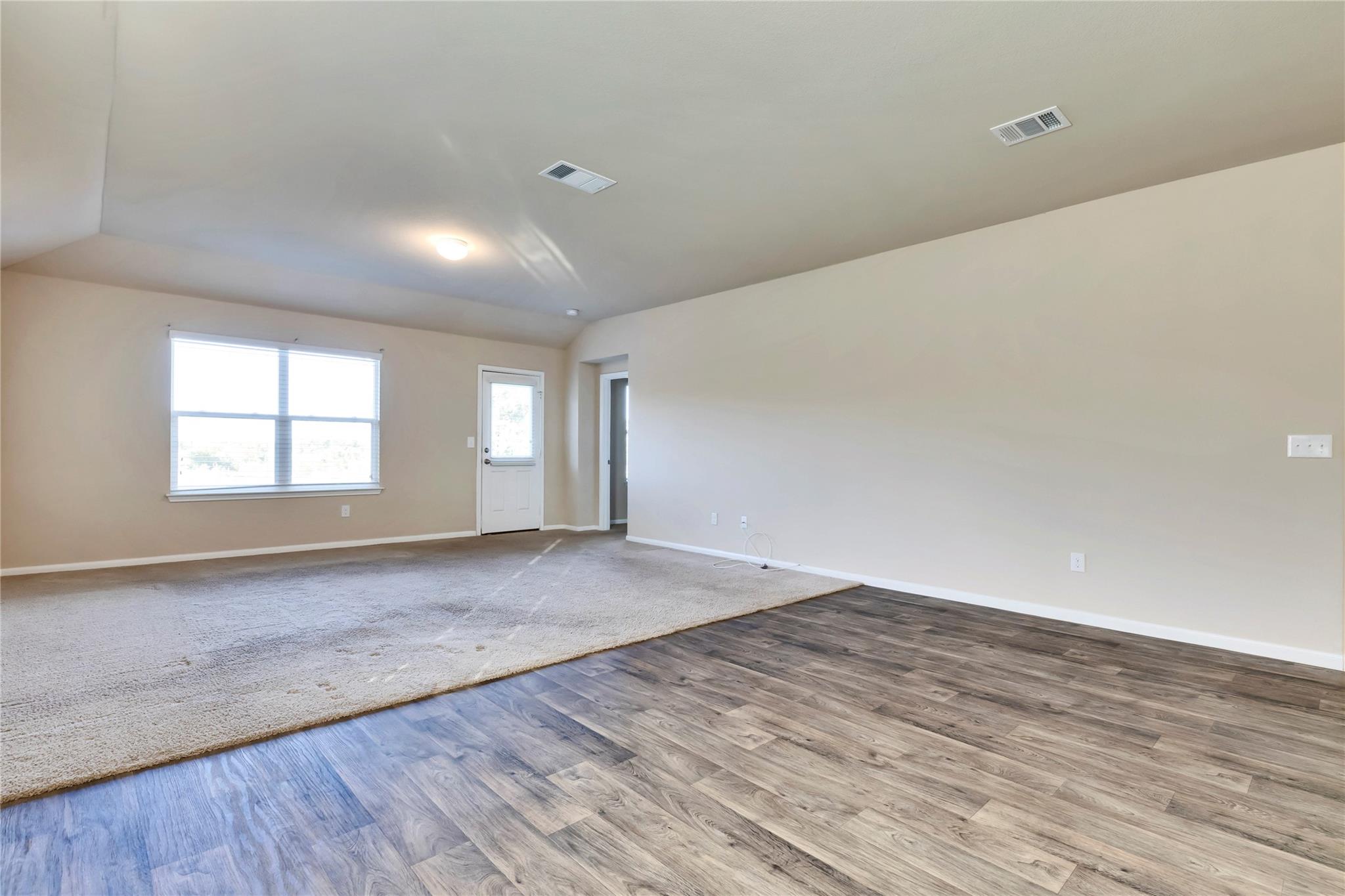 5913 Diamondleaf Bend Austin, TX 78724 - Photo 12 of 20 Expansive open-concept room featuring wood-finish flooring transitioning to carpeting