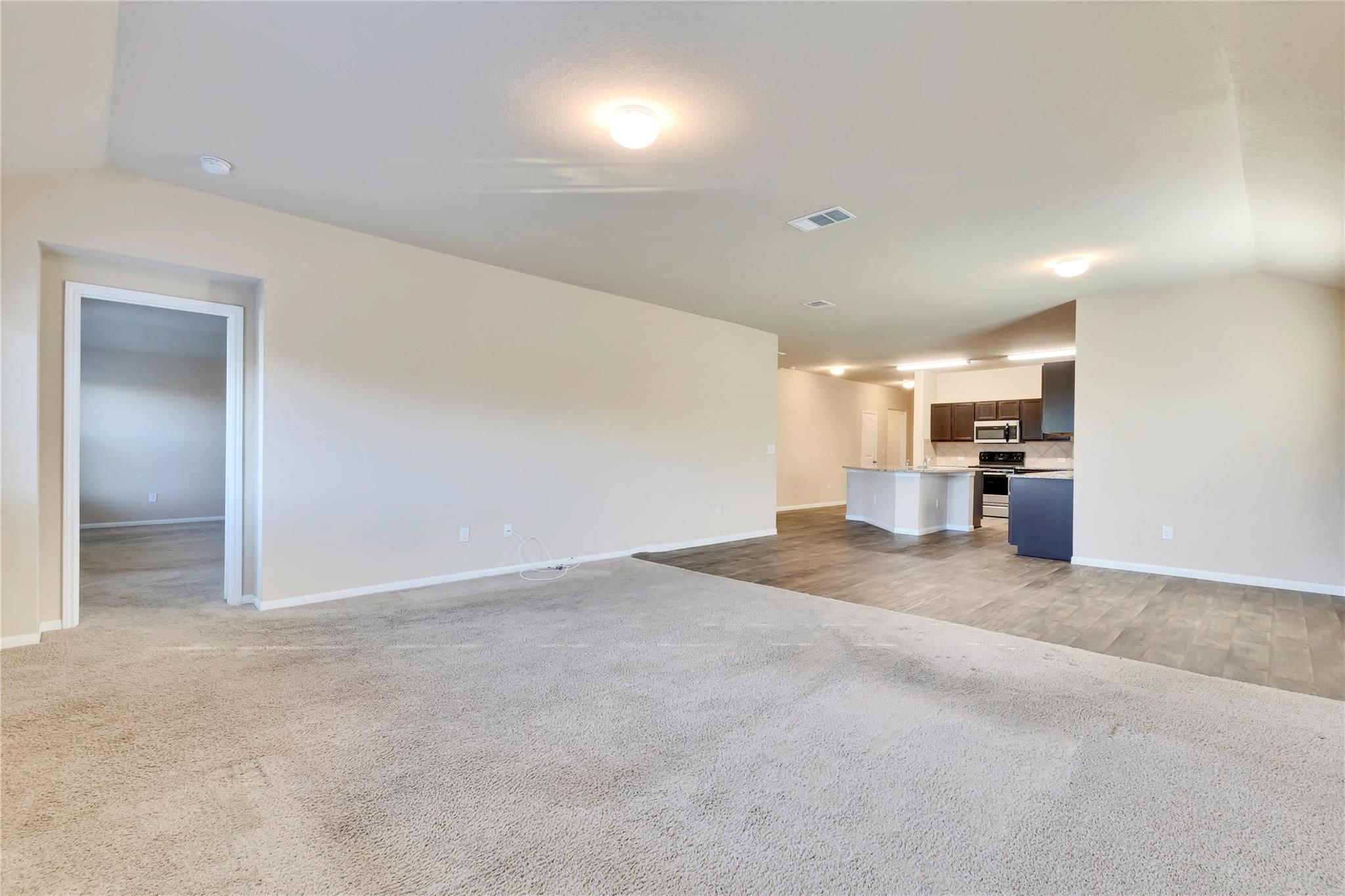 5913 Diamondleaf Bend Austin, TX 78724 - Photo 13 of 20 Spacious open-concept interior featuring light-toned walls and ceiling