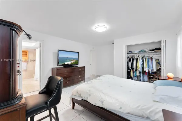 a spacious bedroom with a bed and a flat screen tv