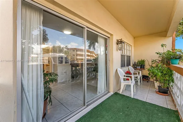 a view of a porch with chairs and floor to ceiling window
