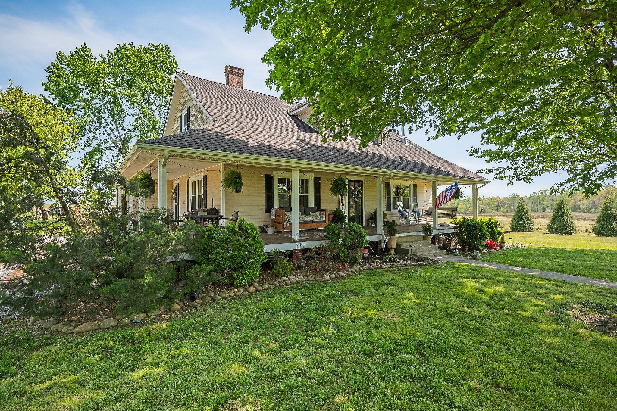 77 McAfee Lane Morrison, TN 37357 - Photo 4 of 39 a view of house in front of a big yard with large trees and lawn chairs