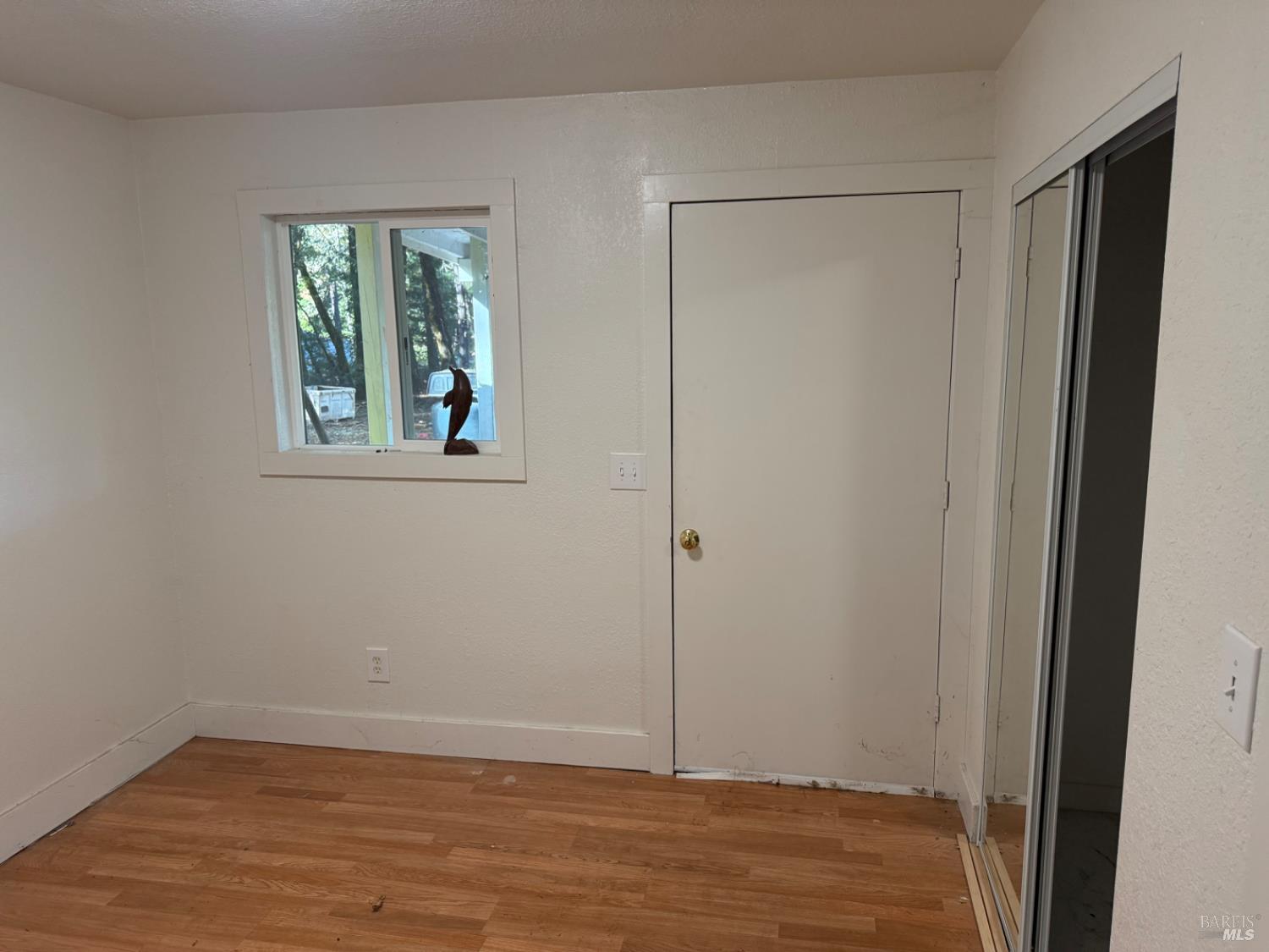 770 Branscomb Road Laytonville, CA 95454 - Photo 16 of 42 a view of an empty room with wooden floor and a window