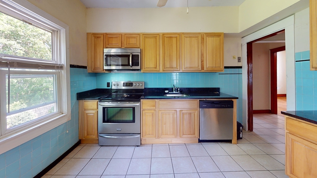 a kitchen with stainless steel appliances a stove a microwave and white cabinets